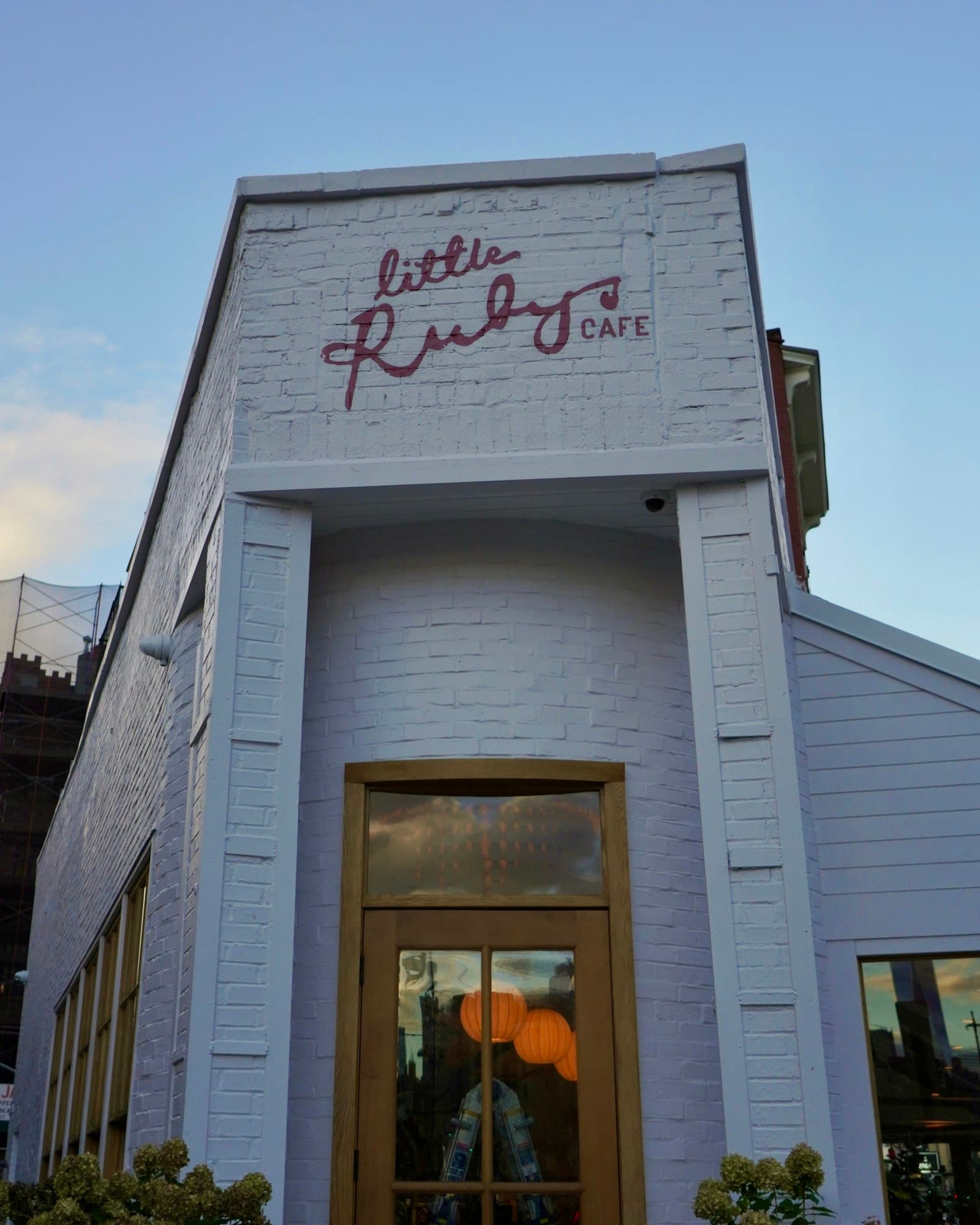 Independent small business storefront exterior at dusk with warm interior lights — business owner asset protection