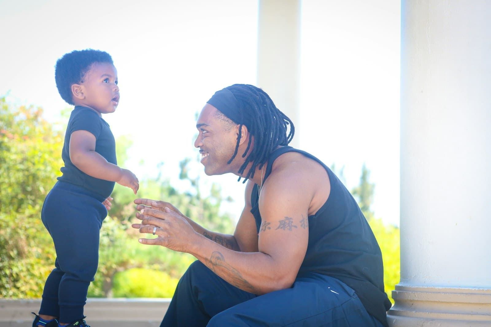 Father smiling warmly at a toddler outdoors in bright sunshine — estate planning for blended families in Texas