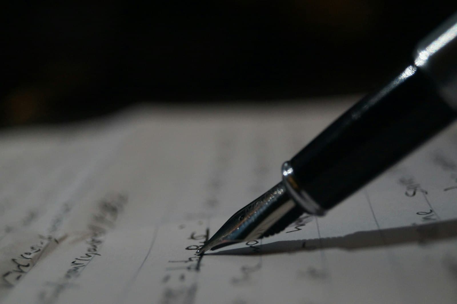 Close-up macro of a fountain pen nib touching handwritten cursive text on lined paper — estate planning documents