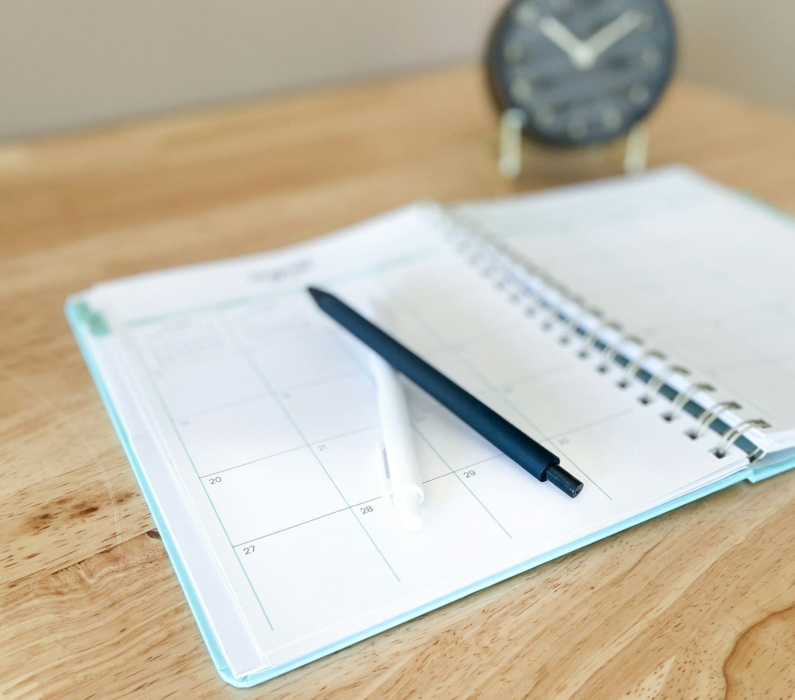 Open calendar planner with a pen resting across it on a warm wooden desk — when to review and update your estate plan