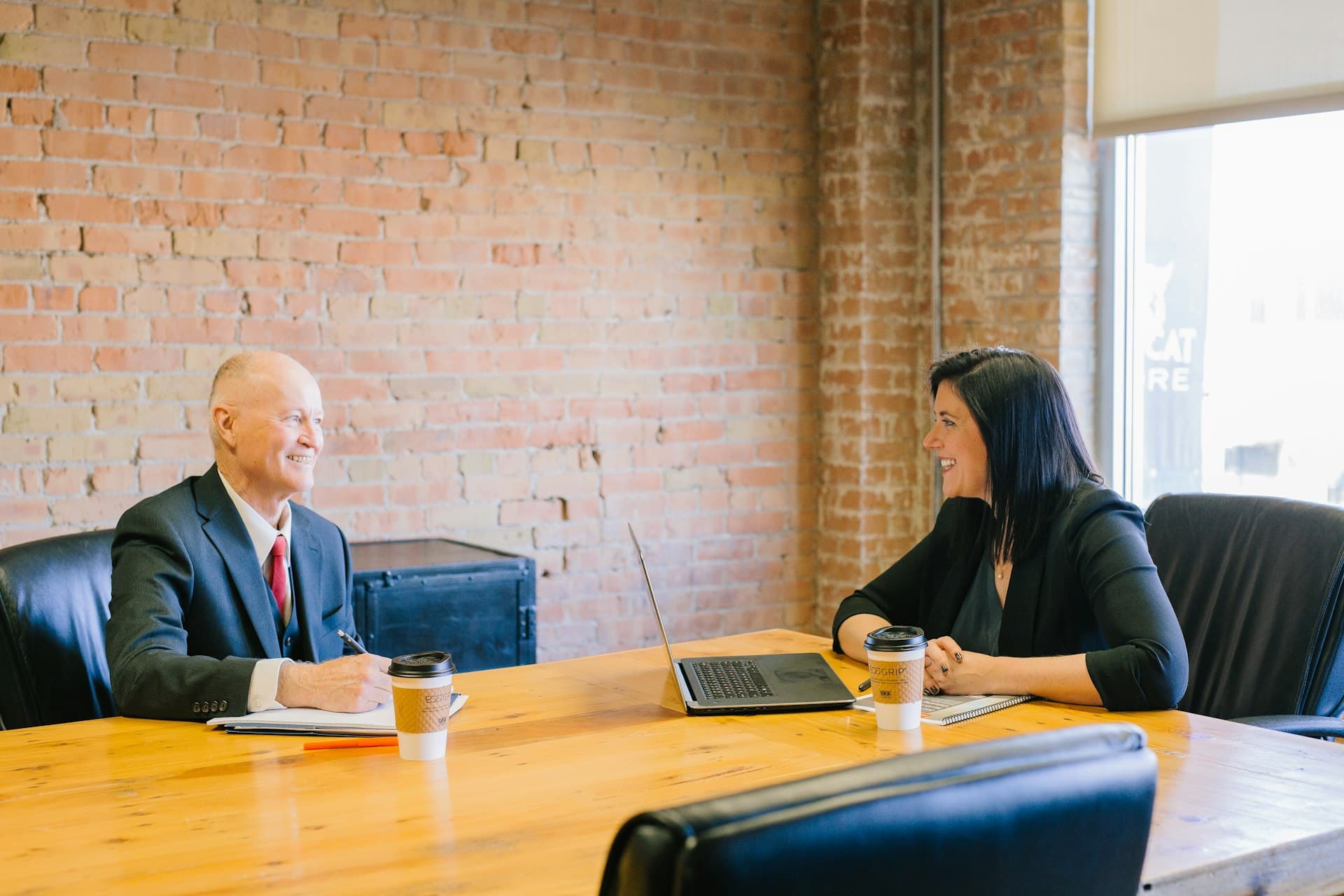 Attorney reviewing documents with a client at a desk in a bright consultation office