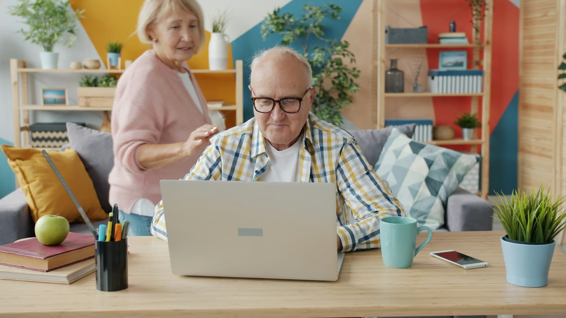 Elderly couple at a desk with a laptop reviewing estate plan documents — probate and trust administration