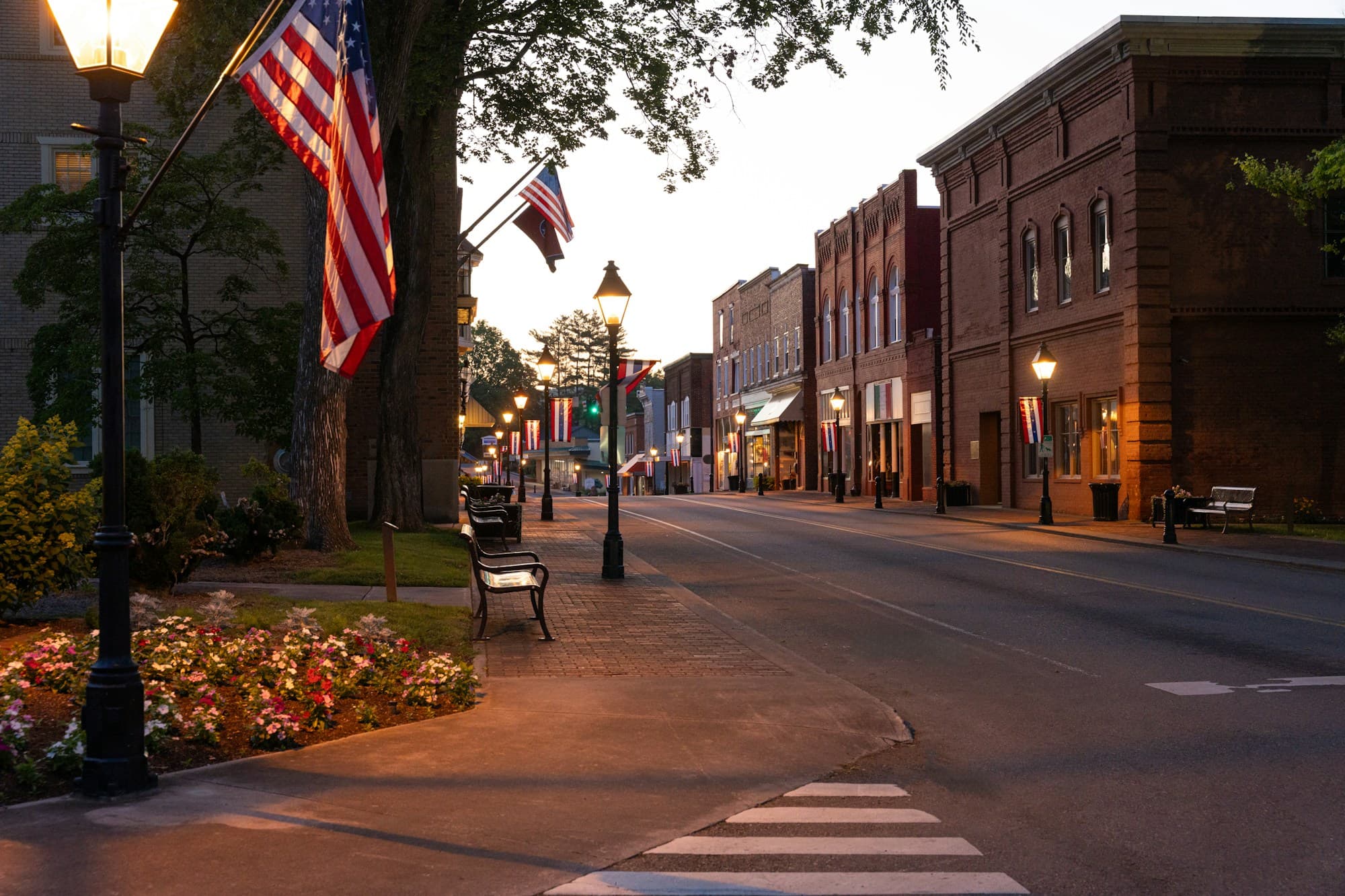 Small-town Texas main street at dusk with flags hanging from historic storefronts